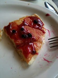 A piece of pancake smothered in huckleberry syrup.