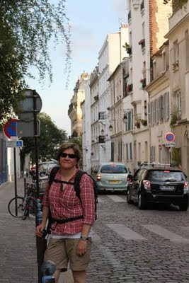 Judy standing against a sign on a French street