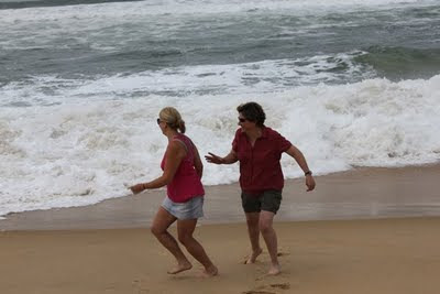 Nikole and Judy running alongside a wave from the ocean