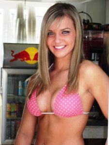 A barista with long blonde hair and large breasts wearing a pink polka dotted bikini