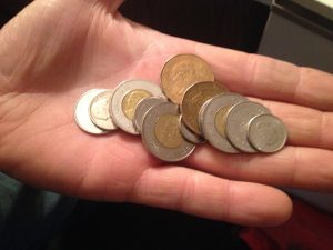 Image of Judy holding several Canadian coins
