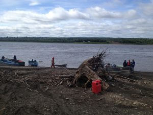 Image of several small boats on the side of the water next to very large debris