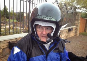 Image of Arlene in full motorcycle attire with large eyes and a shivering appearance 