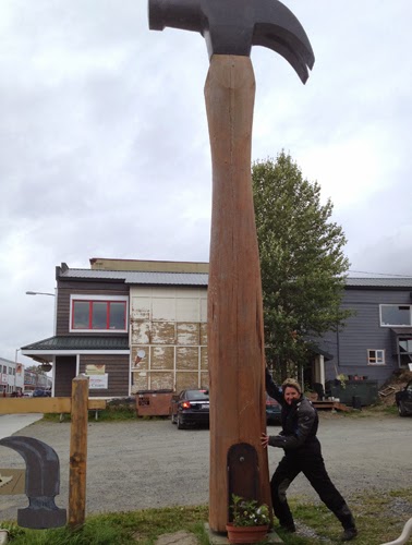 Image of Judy leaning against a very large hammer