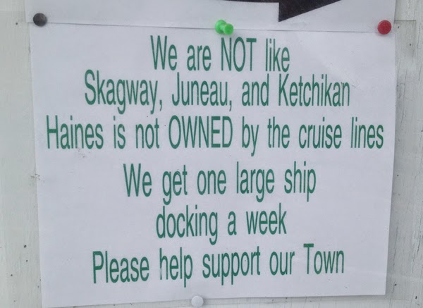 Image of a sign reading, "We are NOT like Skagway, Juneau, and Ketchikan. Haines is now OWNED by the cruise lines. We get one large ship docking a week. Please help support our Town"