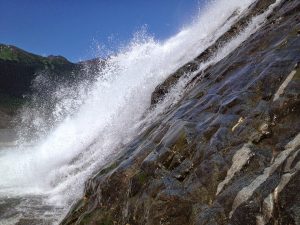 Image of a large spray of water alongside a rockside