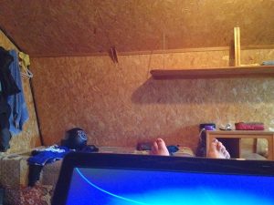 Image of a laptop in a lap with toes peeking out from under